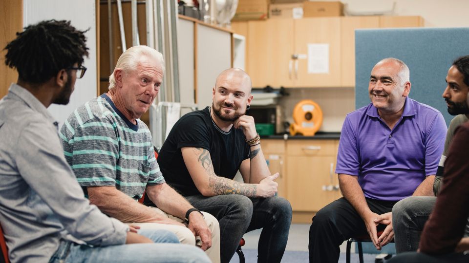 Men talking in a group at a mens shed