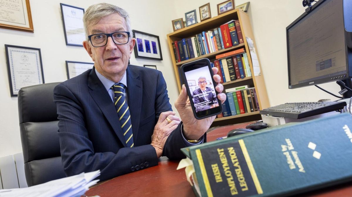 Richard Grogan holding up a phone showing one of his TikTok videos