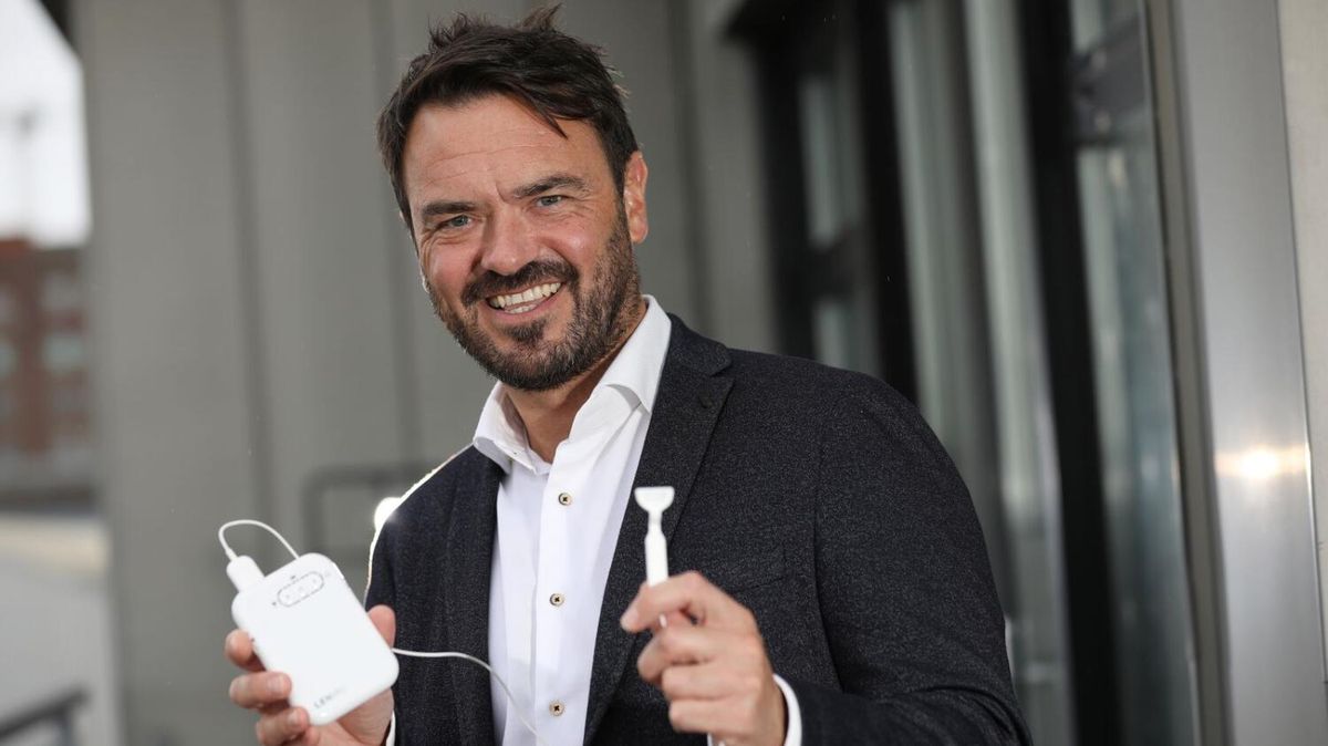 Dr Ross O'Neill of Neuromod Devices holding the Lenire device